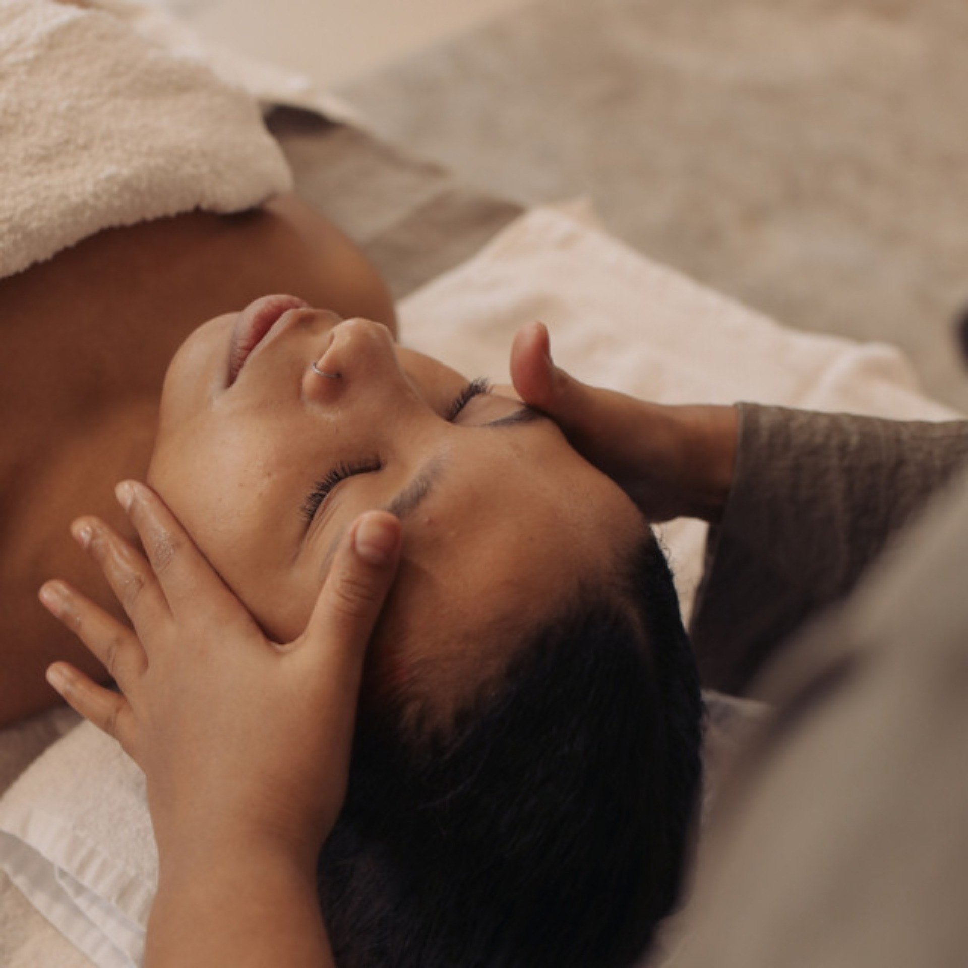 woman lying down receiving a head massage